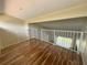 Spacious loft area with wood flooring and white railings at 2066 Sunset Point Rd # 97, Clearwater, FL 33765