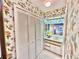 Clean bathroom with a shower, toilet, and updated vanity with floral wallpaper at 2119 Elm St # 101, Dunedin, FL 34698