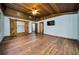 Main bedroom with wood-look floors, barn doors and vaulted ceiling at 4747 Tamney Ln, Land O Lakes, FL 34639