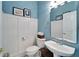 Stylish powder room with white vanity and blue walls at 5614 Seagrass Pl, Apollo Beach, FL 33572