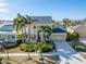Two-story yellow house with palm trees and a paved driveway at 5614 Seagrass Pl, Apollo Beach, FL 33572