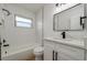 Modern bathroom with white tile, marble countertop, and black fixtures at 8462 8Th N Way, St Petersburg, FL 33702
