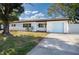 Updated Ranch home with light blue garage door and manicured lawn at 8462 8Th N Way, St Petersburg, FL 33702