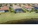 Aerial view of home with screened lanai, lush landscaping, and water view at 10338 Highland Park Pl, Palmetto, FL 34221