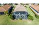 Backyard view of home with screened patio and landscaping at 10338 Highland Park Pl, Palmetto, FL 34221