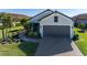 Single-story home with a two-car garage and landscaped yard at 10338 Highland Park Pl, Palmetto, FL 34221