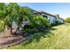 Landscaped backyard with lush greenery and palm trees at 10338 Highland Park Pl, Palmetto, FL 34221
