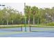 Two well-maintained tennis courts nestled within a lush, tree-lined community at 123 9Th St, Belleair Beach, FL 33786