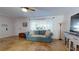 Bright living room with teal couch and tile floors at 14250 86Th Ter, Seminole, FL 33776