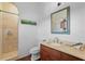 Bathroom with walk-in shower and wood vanity at 1571 Oceanview Dr, St Petersburg, FL 33715