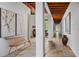 Long hallway with hardwood floors, exposed beams, artwork and a wooden bench at 1571 Oceanview Dr, St Petersburg, FL 33715