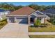 Single-story home with a two-car garage and landscaped yard at 17671 Bright Wheat Dr, Lithia, FL 33547
