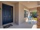 Inviting front porch with blue door and small chair at 17671 Bright Wheat Dr, Lithia, FL 33547