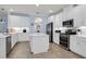 Modern kitchen featuring white cabinets, a center island, and stainless steel appliances at 17671 Bright Wheat Dr, Lithia, FL 33547