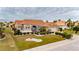 Single-story home with tile roof, lush landscaping, and paved driveway at 2003 Captiva Ct, Sun City Center, FL 33573