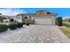 One-story home with tile roof, paver driveway, and lush landscaping at 2003 Captiva Ct, Sun City Center, FL 33573