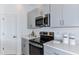 Modern kitchen with stainless steel appliances and gray cabinets at 2123 Hallier Cv, Wesley Chapel, FL 33543