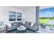 Spacious living area with sectional sofa, sliding glass doors, and lake view at 2123 Hallier Cv, Wesley Chapel, FL 33543