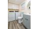 Small bathroom with a toilet, gray vanity, and stacked washer/dryer at 2601 2Nd Ct, Palm Harbor, FL 34684