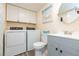 Bathroom with toilet, gray vanity, and stacked washer/dryer at 2601 2Nd Ct, Palm Harbor, FL 34684