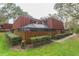 Brick townhouse with red tile roof, screened patio, and fenced yard at 2601 2Nd Ct, Palm Harbor, FL 34684