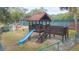 play area with a playhouse, slide, and swings at 2601 2Nd Ct, Palm Harbor, FL 34684