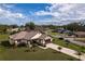 New single-Gathering home with paver driveway and landscaped lawn, aerial view at 2972 Lake Saxon Dr, Land O Lakes, FL 34639