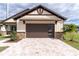 House with a brown garage door and a stone facade at 2972 Lake Saxon Dr, Land O Lakes, FL 34639