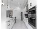 Modern kitchen with white cabinets, stainless steel appliances, and quartz countertops at 2972 Lake Saxon Dr, Land O Lakes, FL 34639