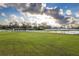 Green pasture with white fencing and stables at 2972 Lake Saxon Dr, Land O Lakes, FL 34639