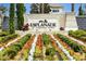 The entrance to the Esplanade at Wiregrass Ranch showcases meticulous landscaping with flowers and mature shrubs at 29800 Cassino Ct, Wesley Chapel, FL 33543