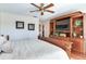 Main bedroom with a king-size bed, built in entertainment center and ceiling fan at 3050 Maple Trce, Tarpon Springs, FL 34688