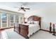 Bedroom with large windows, a king-size bed, and a ceiling fan at 3050 Maple Trce, Tarpon Springs, FL 34688