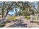 Long driveway entrance with white gates, leading to a charming house at 3050 Maple Trce, Tarpon Springs, FL 34688