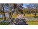 Long driveway entrance with white fence and gate leading to home at 3050 Maple Trce, Tarpon Springs, FL 34688
