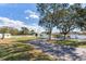 Ranch-style home with a long driveway and green lawn at 3050 Maple Trce, Tarpon Springs, FL 34688