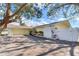 Ranch home with attached garage and a white fence at 3050 Maple Trce, Tarpon Springs, FL 34688