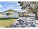 Yellow ranch house with stone accents and a spacious yard at 3050 Maple Trce, Tarpon Springs, FL 34688