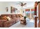 Living room with a brown leather sectional sofa and large windows at 3050 Maple Trce, Tarpon Springs, FL 34688
