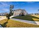 Two-story house with beige exterior, two-car garage, and a large front yard at 38296 Sonnet Landing Ave, Zephyrhills, FL 33540