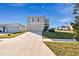 Two-story house with beige exterior, two-car garage, and a well-maintained lawn at 38296 Sonnet Landing Ave, Zephyrhills, FL 33540