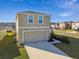 Tan two-story house with a two-car garage at 38296 Sonnet Landing Ave, Zephyrhills, FL 33540