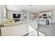 Open living room and kitchen with grey carpet and large sectional sofa at 38296 Sonnet Landing Ave, Zephyrhills, FL 33540