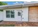 White front door entryway with a wood accent wall and brick pavers at 4104 W Marietta St, Tampa, FL 33616