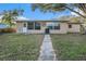 Tan house with large windows and walkway at 415 Country Club Dr, Oldsmar, FL 34677