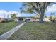 Tan house with large windows and walkway at 415 Country Club Dr, Oldsmar, FL 34677