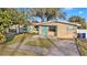 Tan house with teal accents and walkway at 415 Country Club Dr, Oldsmar, FL 34677