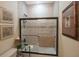 Bright bathroom featuring tiled shower with glass doors and decorative wall art at 4884 Yacht Club Dr, Tampa, FL 33616