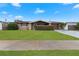 Front view of a ranch house with a lush green lawn at 5147 Perennial Dr, Holiday, FL 34690