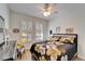 Bedroom with plantation shutters and a floral comforter set at 5320 Golden Isles Dr, Apollo Beach, FL 33572